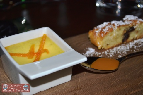 A small bowl of creme bruelee, a slice of cake and a spoon of caramel sauce.