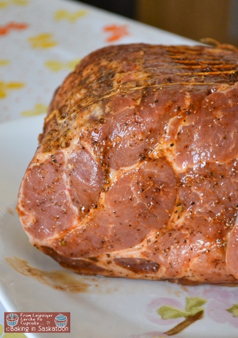 A pork should rubbed with spices on a plate